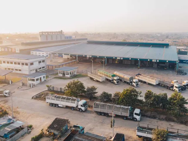 Aerial view factory trucks parked near warehouse daytime (1)